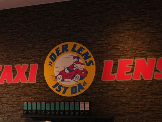 Logowand „Taxi Lens – Der Lens ist da“ im Büro in Oldenburg